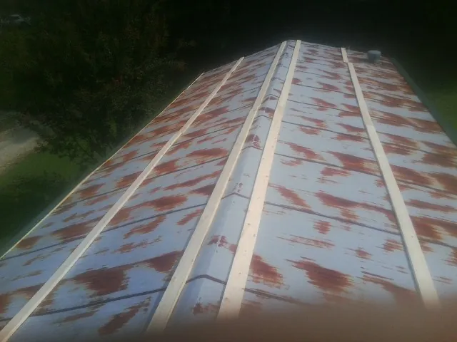 Rusted metal roof panels with new wood purlins before replacement — Storm Damage Roof Repair in North Pitcher by Roofing Brothers